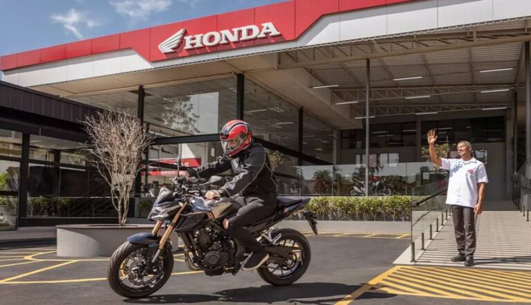 concessionaria honda com colaborador e motociclista a frente - Moto Honda Motopel