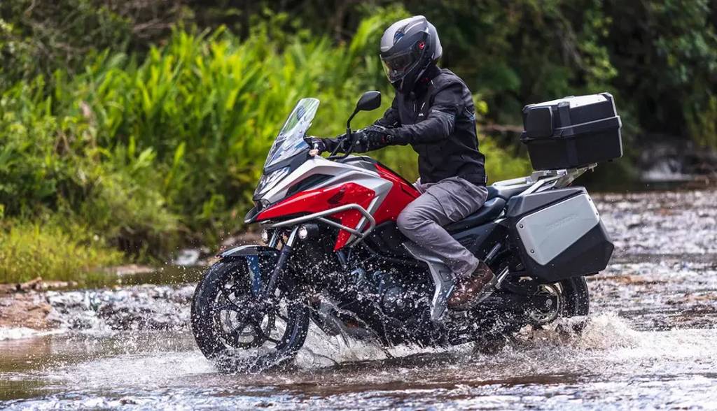 piloto com sua moto honda nc 750x atravessando rio - Moto Honda Motopel