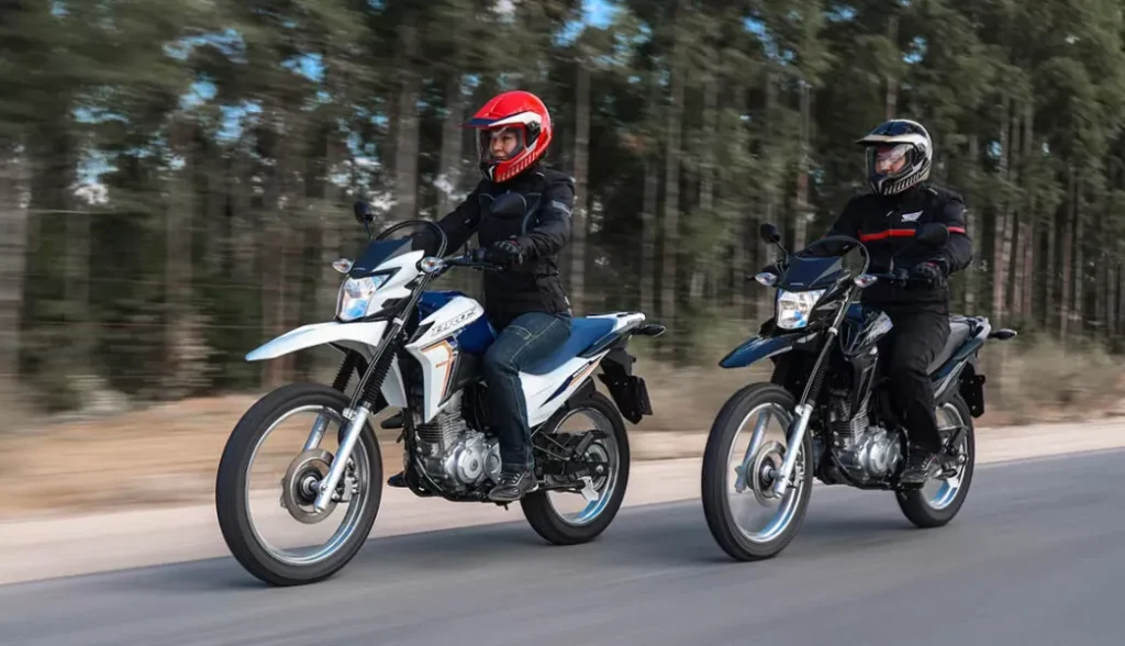 dois pilotos na estrada em suas motocicletas honda nxr 160 bros esdd 2024 uma mulher em uma bros branca e um homem em uma bros preta - Moto Honda Motopel