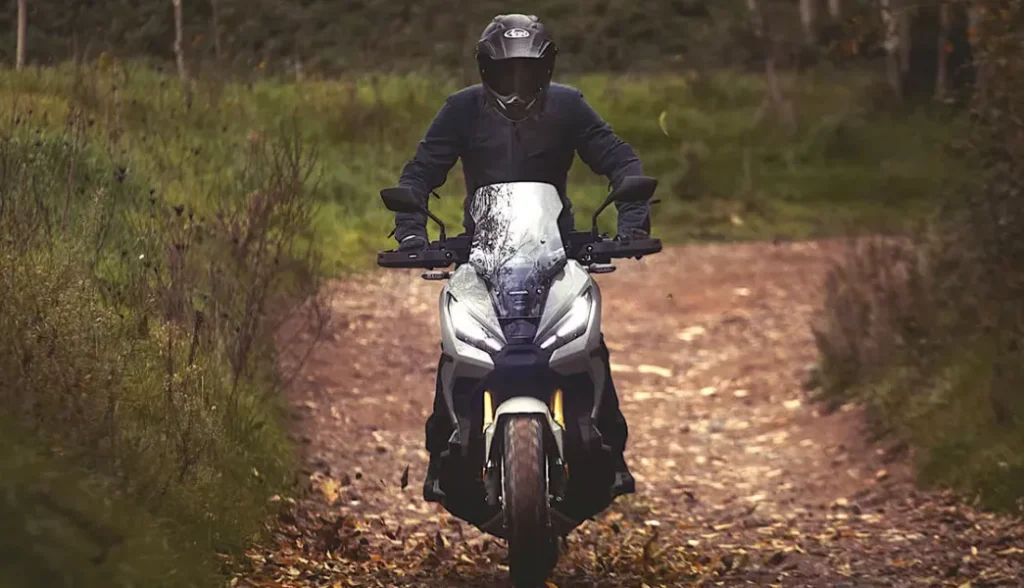 piloto em sua honda x adv em estrada no meio da natureza - Moto Honda Motopel