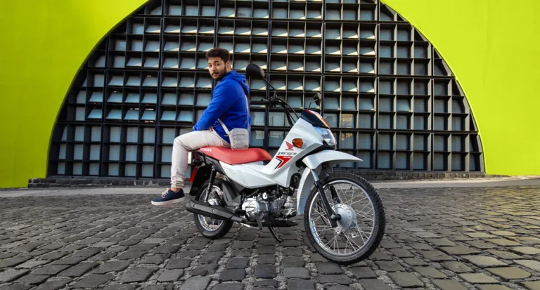 homem montado na motocicleta pop 110i es branco ross white enquanto pousa para camera - Moto Honda Motopel