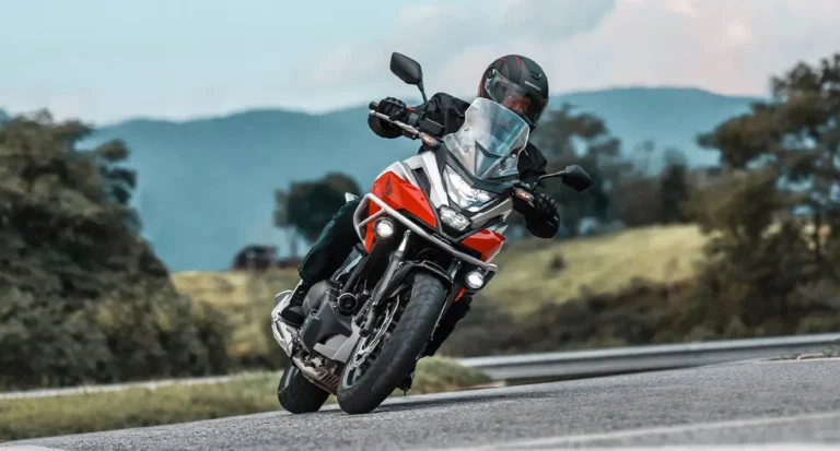 piloto em sua honda nc 750x fazendo curva na estrada - Moto Honda Motopel